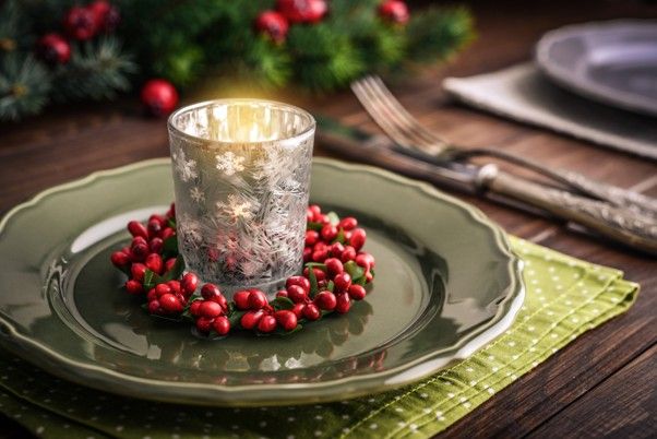 Weihnachtlicher Kerzenhalter mit Schneeflockenmotiv und rotem Beerenkranz auf grünem Teller