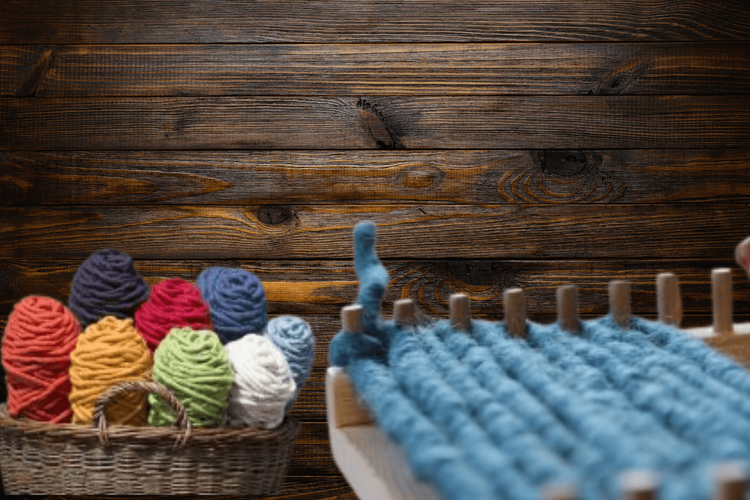 Bunte Wollknäuel im Korb und blaues gestricktes Gewebe auf Holzuntergrund