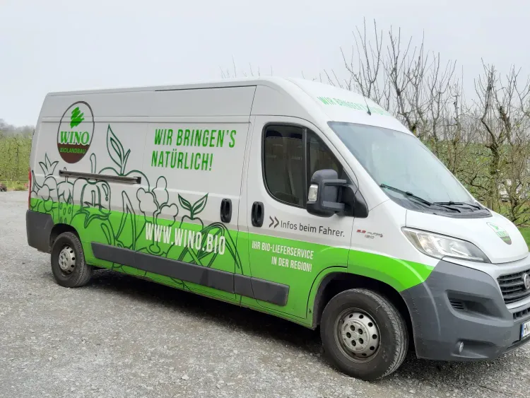 Weißer Lieferwagen mit grünem Design und Aufschrift für Bio-Lieferservice WINO Biolandbau
