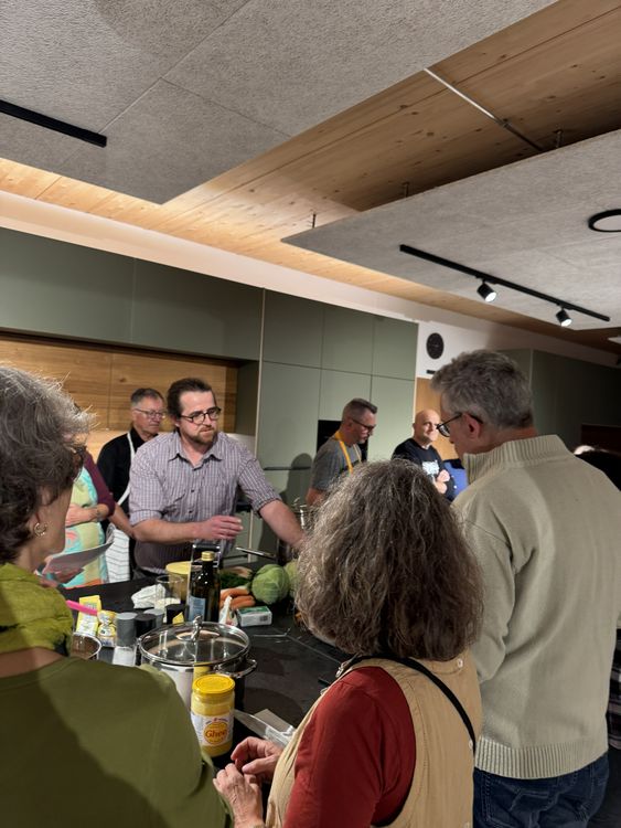 Gruppe von Erwachsenen nimmt an einem Kochkurs in einer modernen Küche teil