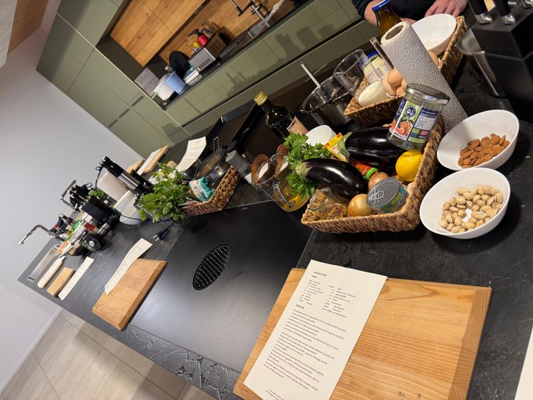 Küche mit Zutaten, Kochanleitung und Schneidebrettern für ein Kochprojekt vorbereitet