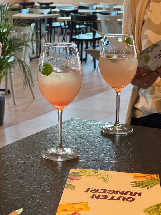 Zwei Gläser mit einem erfrischenden Getränk und Minzblättern auf einem Tisch in einem Café