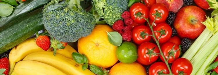 Verschiedene frische Obst- und Gemüsesorten wie Bananen, Tomaten, Brokkoli und Äpfel bunt angeordnet