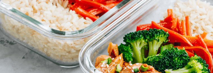 Zwei Glasbehälter mit Reis, Karotten, Brokkoli und Hähnchen in Sesamsoße als gesunde Mahlzeit