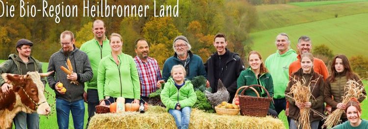 Gruppe von Menschen mit Ernteprodukten und Tieren in herbstlicher Landschaft der Bio-Region Heilbronner Land