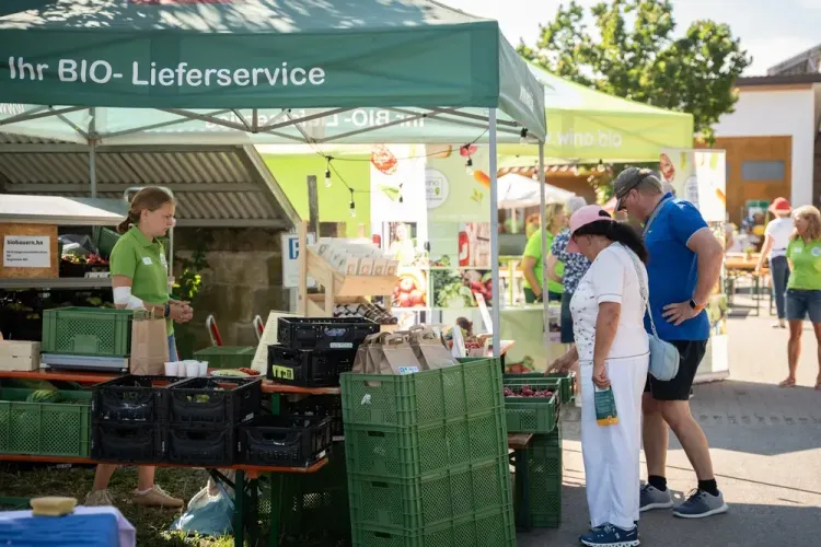 Menschen kaufen frisches Obst an einem Bio-Lieferservice-Stand auf einem Markt im Freien