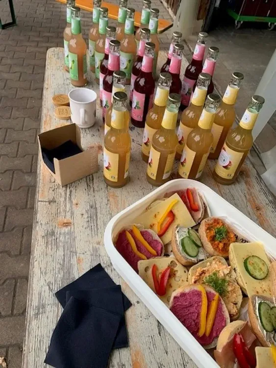 Verschiedene Sandwiches mit Getränken auf einem Holztisch bei einer Veranstaltung