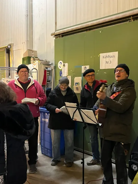 Gruppe von älteren Menschen singt und spielt Gitarre in einem Lager neben Kühlraum Nr. 3