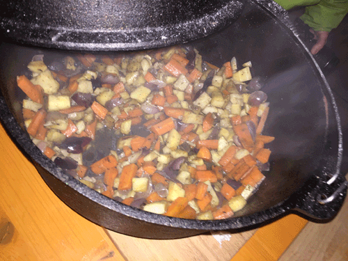 Gemüse aus Karotten, Zwiebeln und anderen Zutaten wird im großen gusseisernen Topf gedünstet